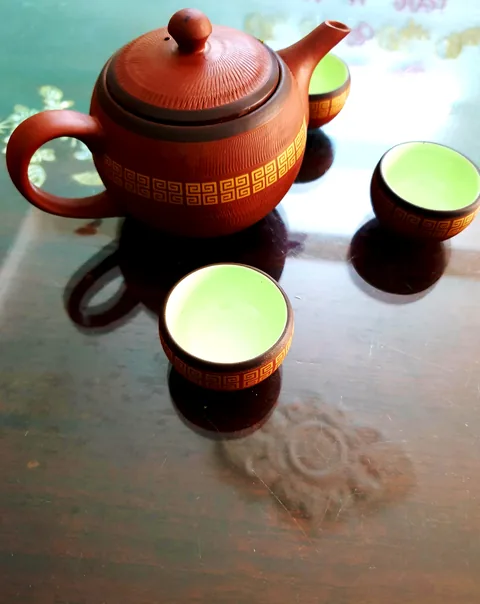 Ấm đất nung và ba chén trà xanh Thái Nguyên trên bàn